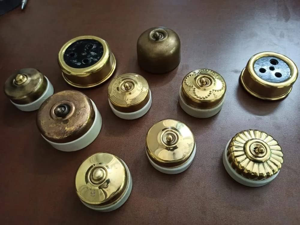 Traditional colonial-style ceramic rotary switches with brass accents—heritage plantation bungalow interior in the Western Ghats.