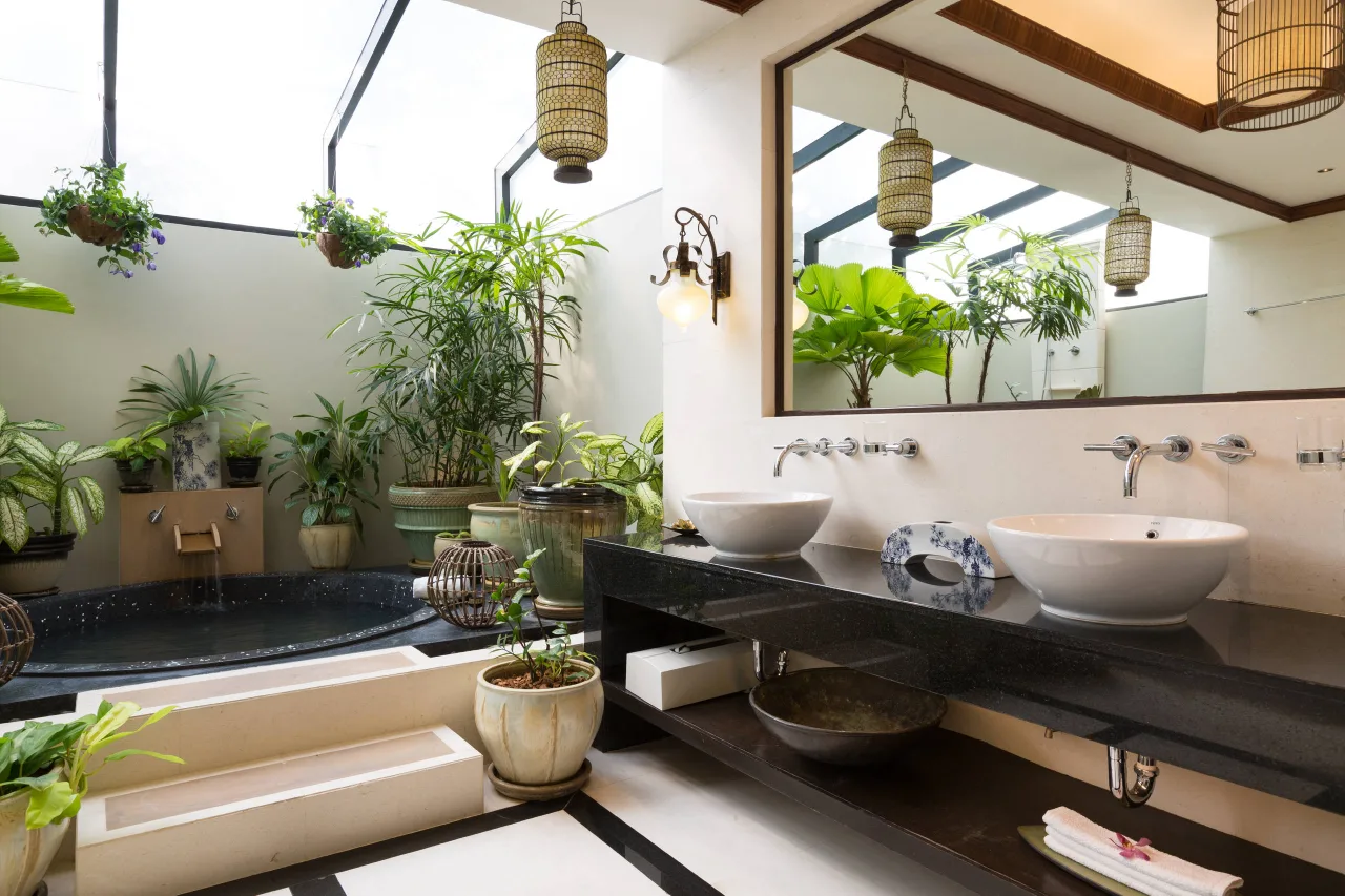 Traditional Kerala style bathroom with a central skylight (Vatila), brass fixtures, and terracotta accents—heritage NRI home in Palakkad.